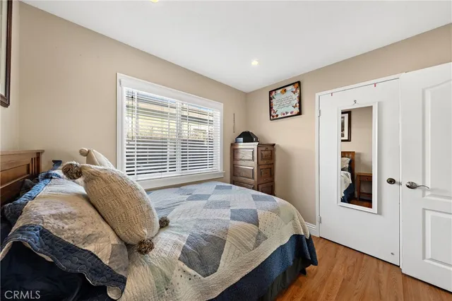 a bed sitting in a bedroom next to a window and a wooden floor
