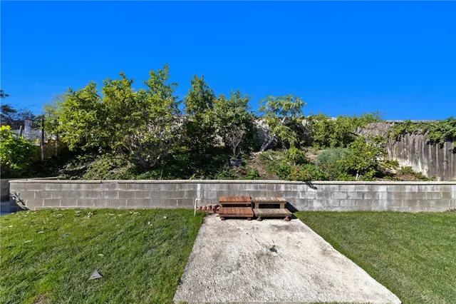 a view of yard with swimming pool and trees in the background