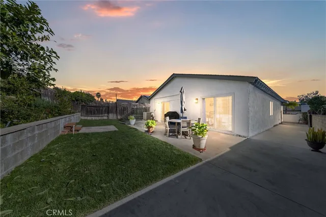 a view of a house with backyard and sitting area