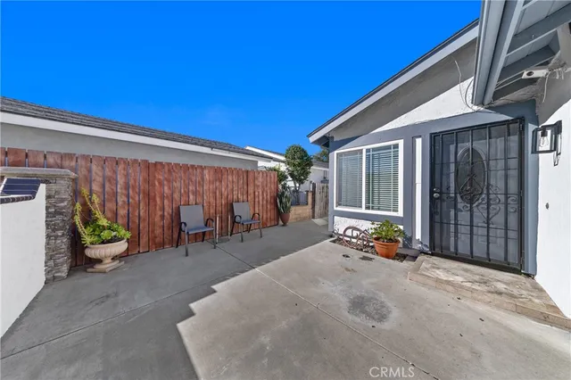 a view of a patio with table and chairs and wooden fence and plants