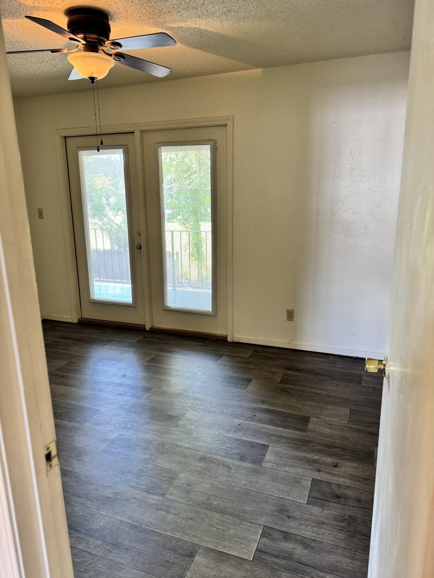 151 Boone Street, Unit G104 Pensacola, FL 32505 - Photo 3 of 7 an empty room with wooden floor and windows