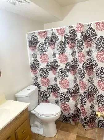 a white toilet sitting next to a shower curtain