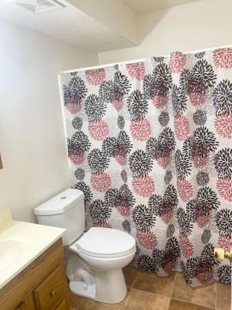 151 Boone Street, Unit G104 Pensacola, FL 32505 - Photo 4 of 7 a white toilet sitting next to a shower curtain