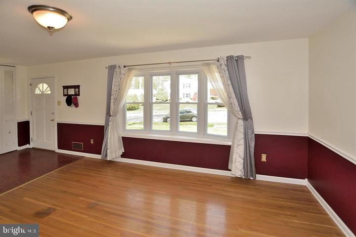 8303 Brixton Street Springfield, VA 22152 - Photo 2 of 5 a view of an empty room with window and wooden floor