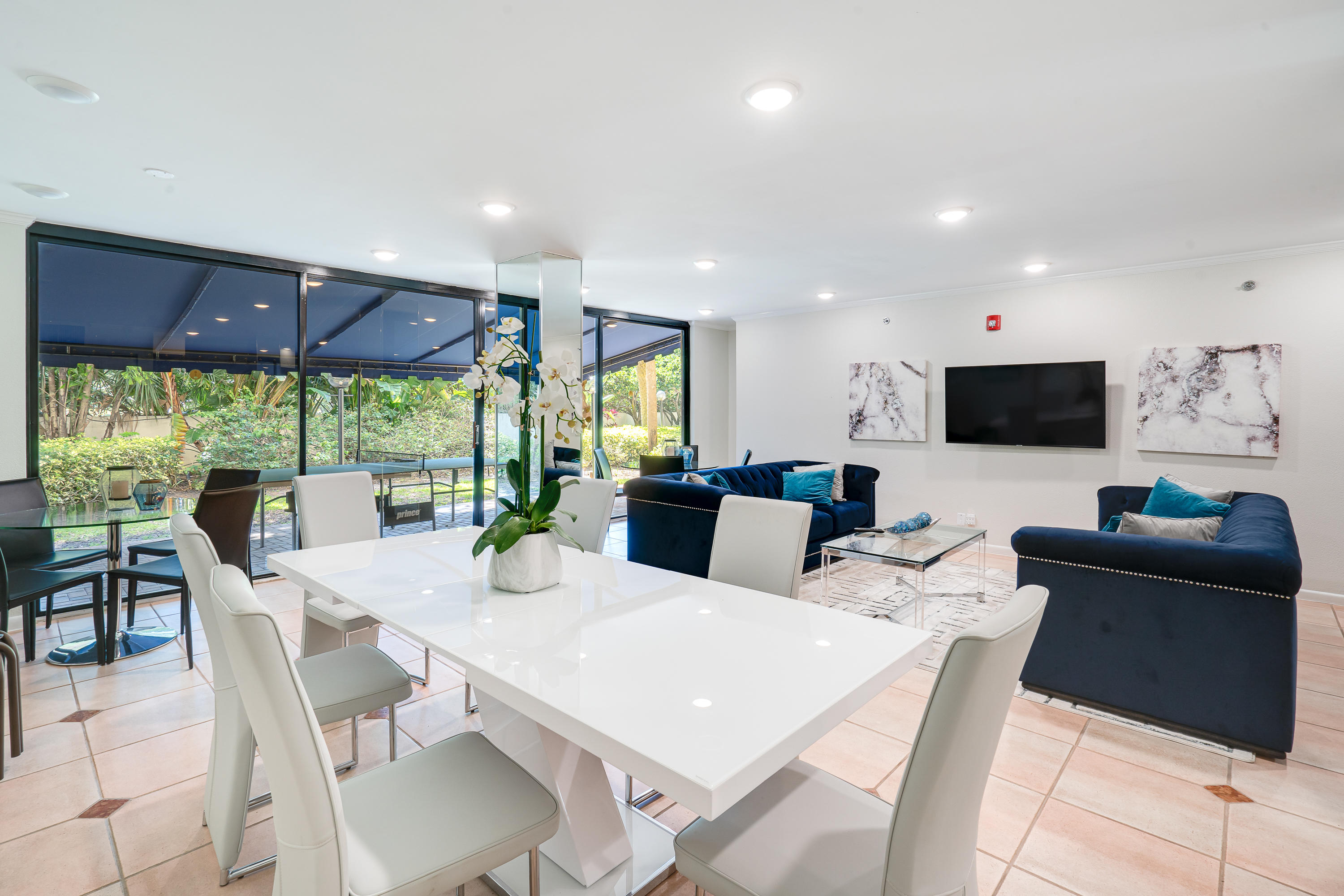 23200 Camino Del Mar, Unit 301 Boca Raton, FL 33433 - Photo 21 of 22 a view of a dining room with furniture large windows and a flat screen tv