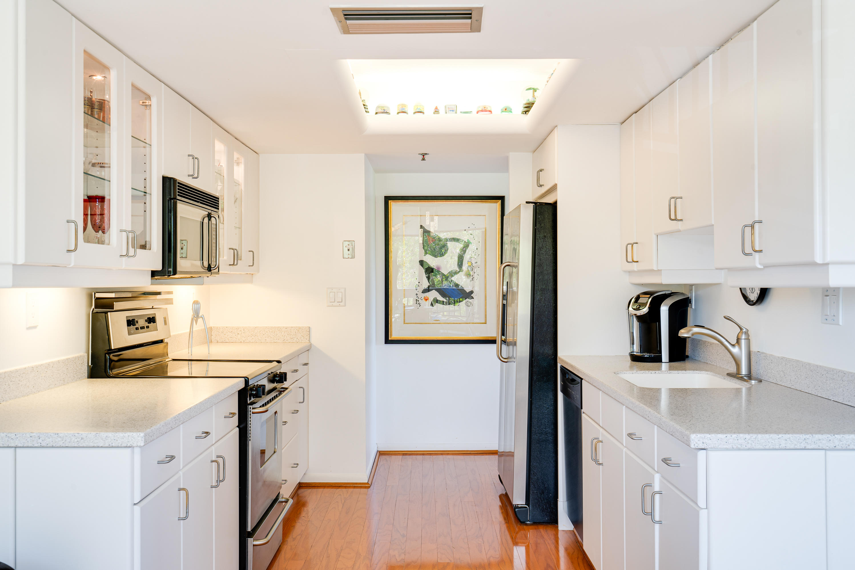 23200 Camino Del Mar, Unit 301 Boca Raton, FL 33433 - Photo 3 of 22 a kitchen with stainless steel appliances a sink a stove a refrigerator a white counter top space and cabinets