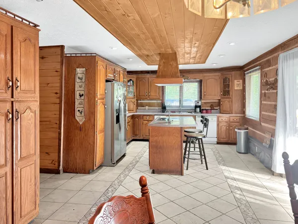 a kitchen with stainless steel appliances wooden cabinets a dining table and chairs