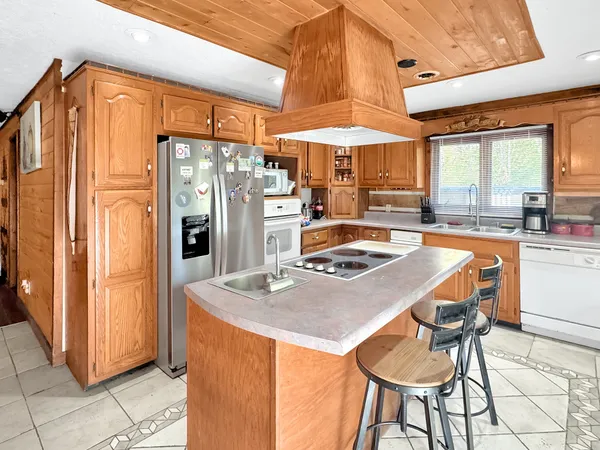 a kitchen with stainless steel appliances granite countertop a refrigerator a sink and a stove