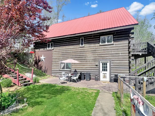 a backyard of a house with table and chairs