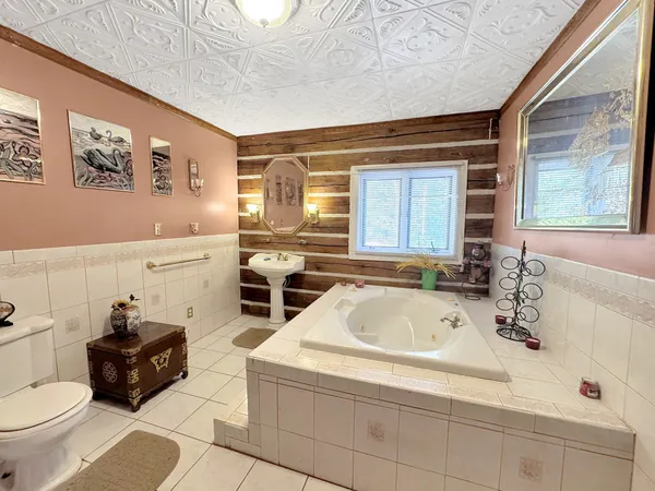a bathroom with a tub sink and mirror