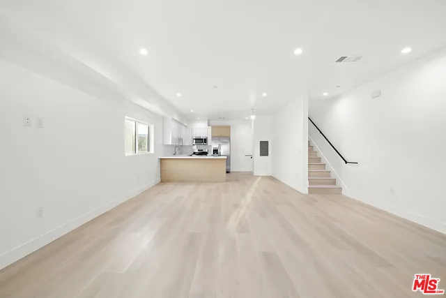 a view of kitchen and hall with wooden floor