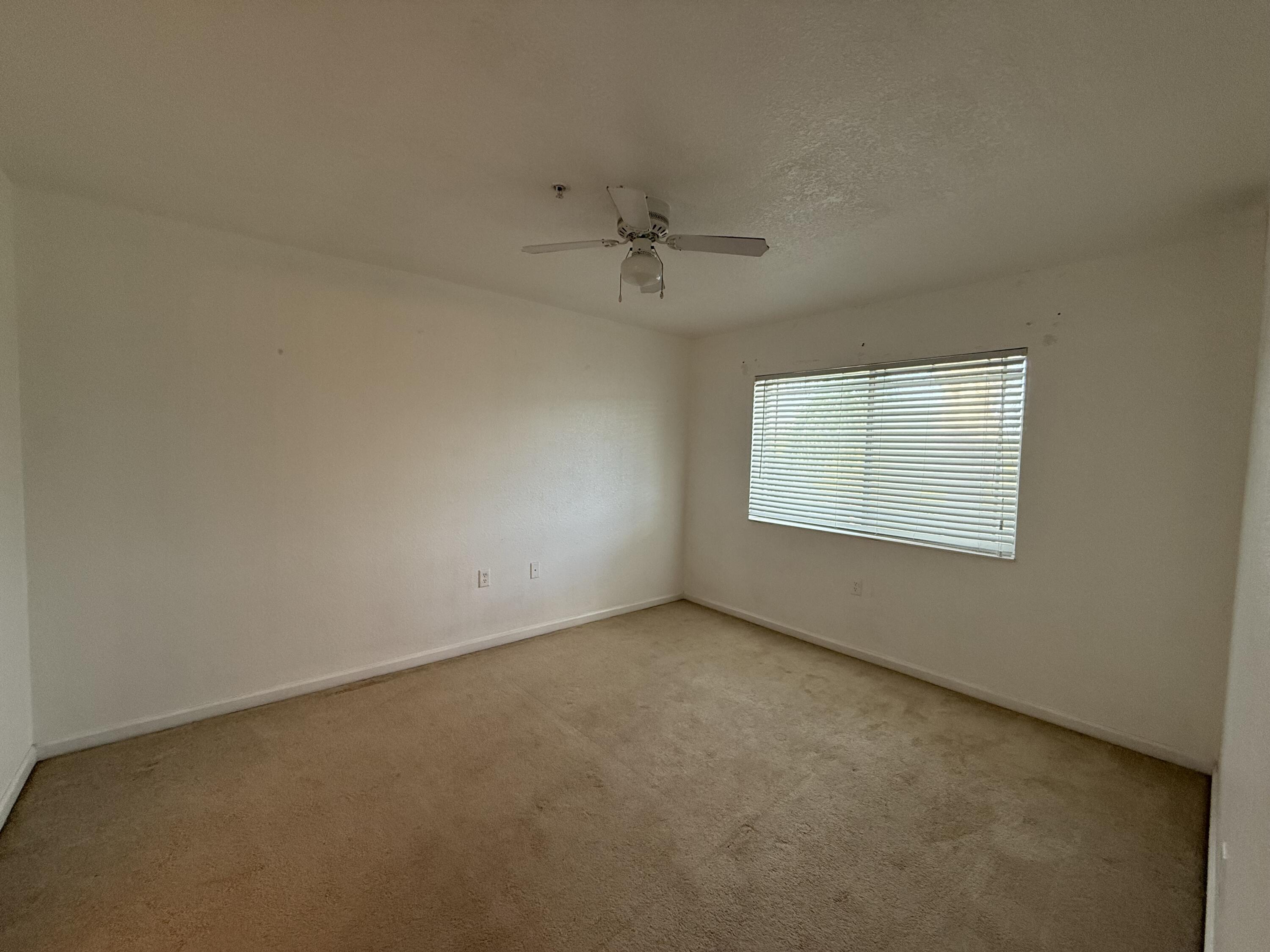301 Southwest Palm Drive, Unit 305 Port St. Lucie, FL 34986 - Photo 6 of 17 an empty room with a window and a ceiling fan