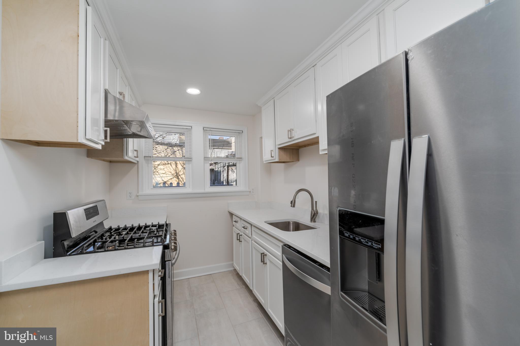 116 South Durham Street Baltimore, MD 21231 - Photo 21 of 28 a kitchen with stainless steel appliances granite countertop a sink a stove and a refrigerator