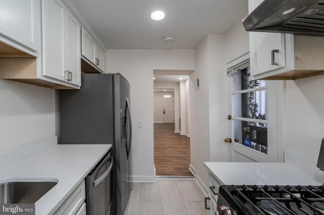 a kitchen with stainless steel appliances granite countertop a refrigerator and a stove top oven