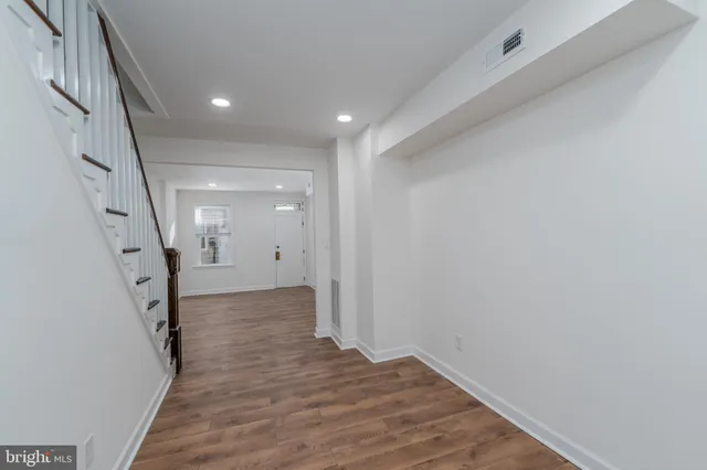 a view of a hallway with wooden floor and staircase