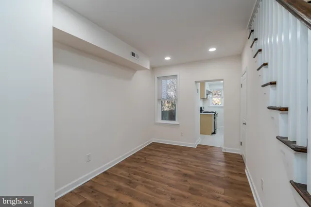 a view of empty room with wooden floor