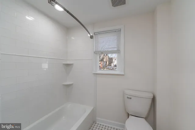 a white toilet sitting next to a bath tub