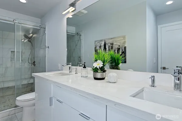 a bathroom with a sink a toilet and shower