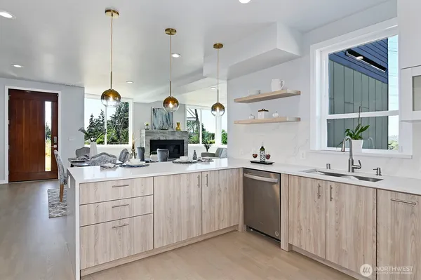 a kitchen with kitchen island granite countertop a sink cabinets and stainless steel appliances