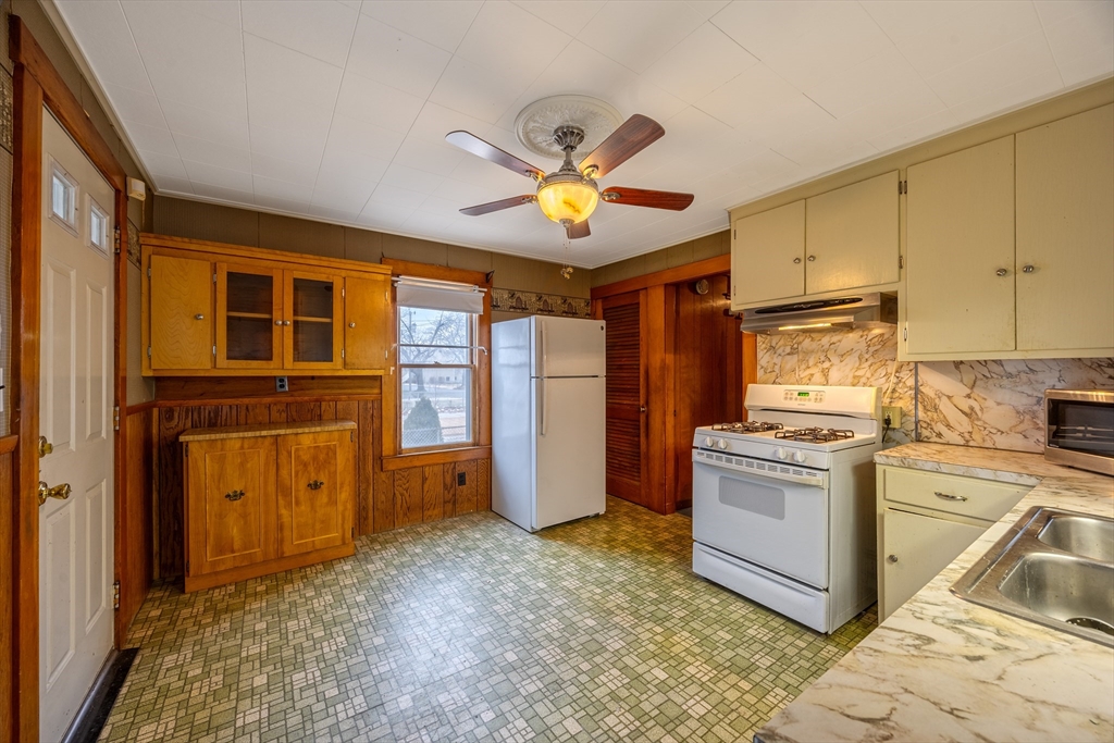 97 Oklahoma Street Springfield, MA 01104 - Photo 3 of 25 a kitchen with stainless steel appliances granite countertop a stove a sink and a refrigerator