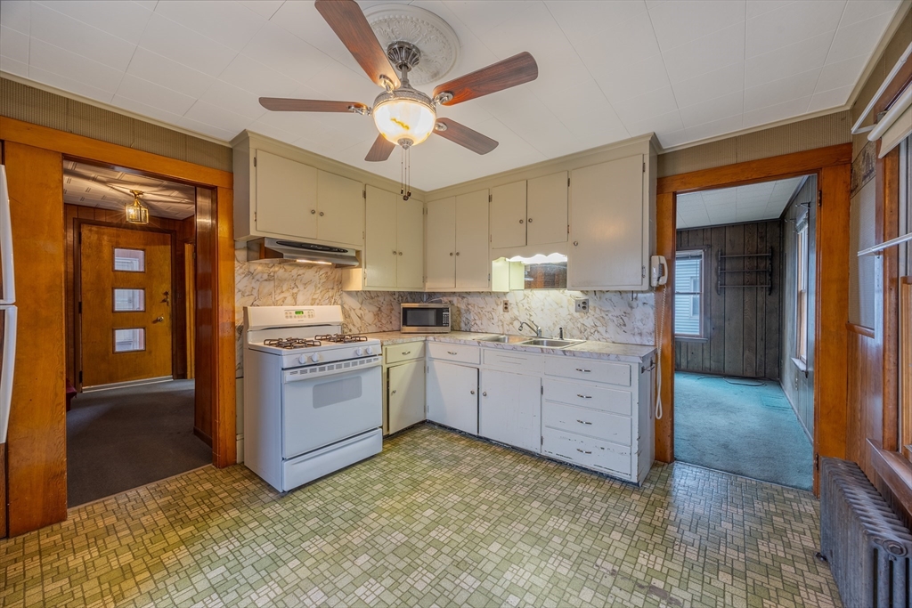 97 Oklahoma Street Springfield, MA 01104 - Photo 5 of 25 a kitchen with granite countertop a sink cabinets stainless steel appliances and a counter top space