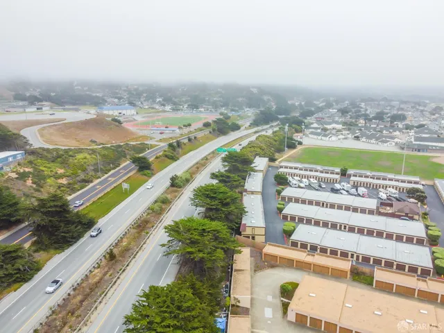 a view of a street with a cars parked in front of it