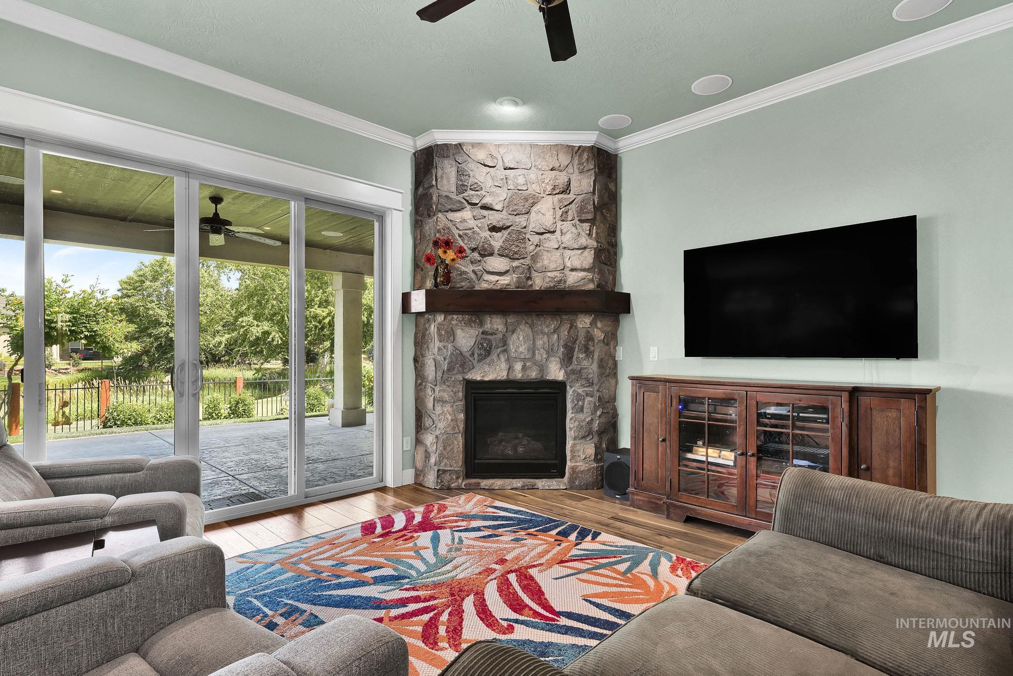 220 South Wildgrass Way Star, ID 83669 - Photo 5 of 50 Inviting living space featuring wood-finish flooring, a stone-clad fireplace with wood mantle, and sliding glass doors to the exterior