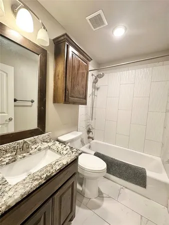 a bathroom with a granite countertop sink toilet and shower