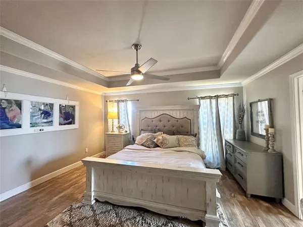 a bedroom with a bed wooden floor and window