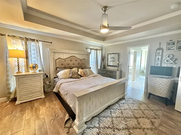a bedroom with a large bed and a chandelier
