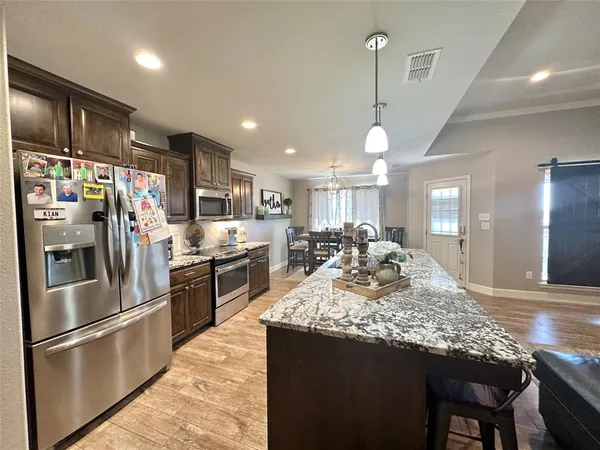 a kitchen with stainless steel appliances granite countertop a sink refrigerator and cabinets