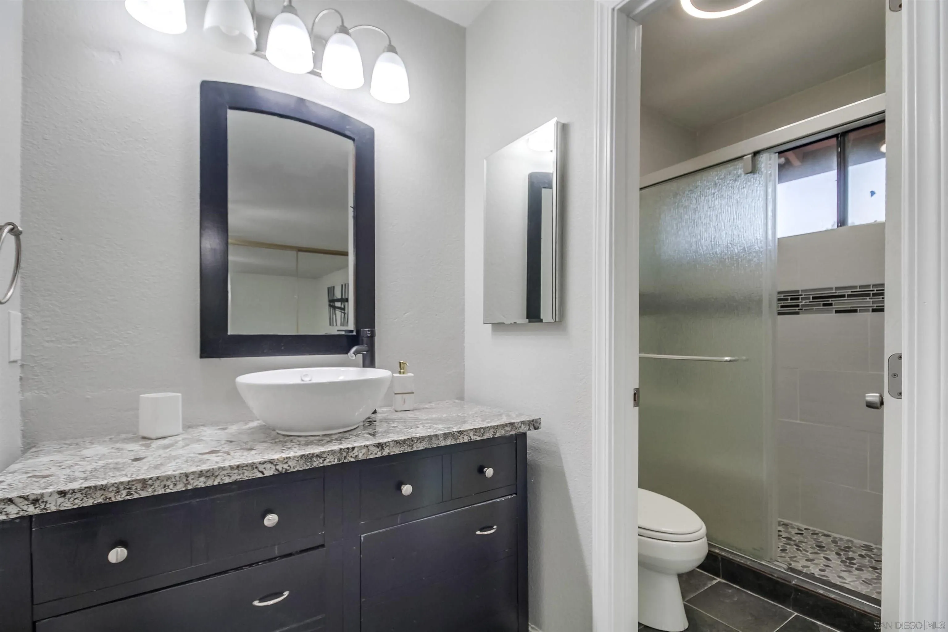 2351 Star Pine Drive Lemon Grove, CA 91945 - Photo 18 of 44 a bathroom with a granite countertop sink toilet and shower