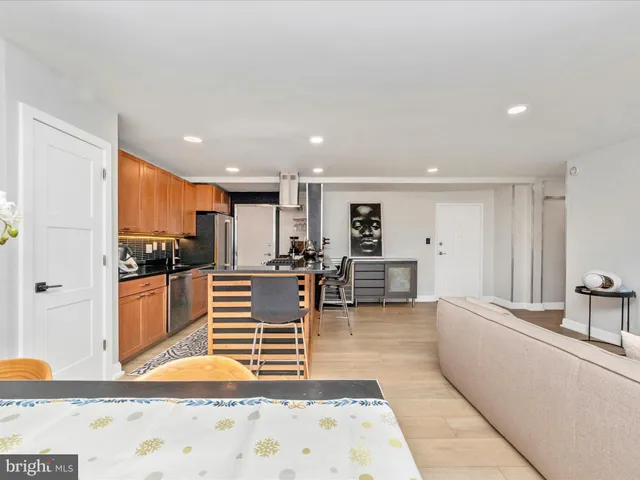 a kitchen with stainless steel appliances kitchen island granite countertop a refrigerator and a sink