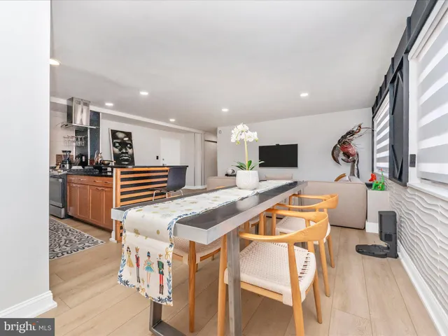 a living room with stainless steel appliances furniture and a flat screen tv