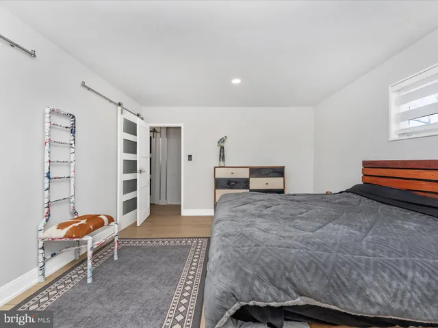 a bedroom with a bed and dresser with mirror