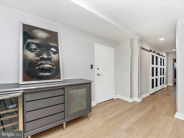 a view of a hallway with closet and wooden floor