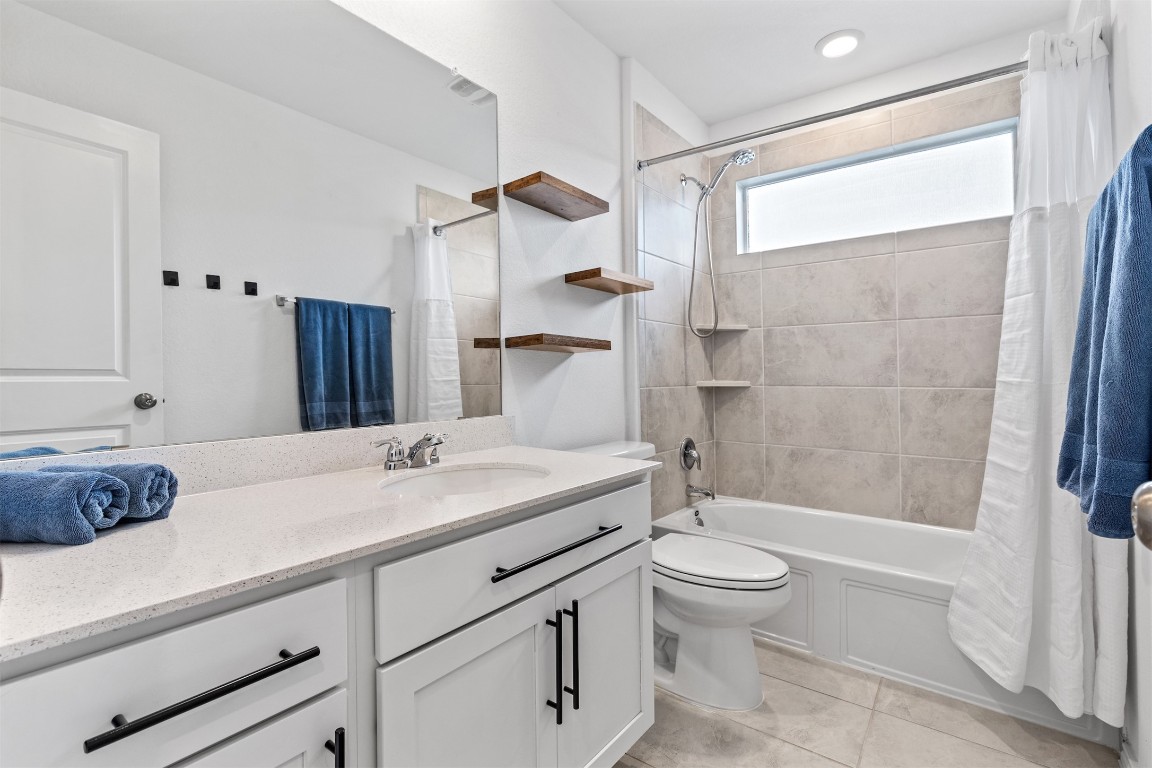 432 Clear Springs Road Georgetown, TX 78628 - Photo 16 of 27 Full bathroom featuring vanity, shower / bath combo with shower curtain, and light tile patterned flooring