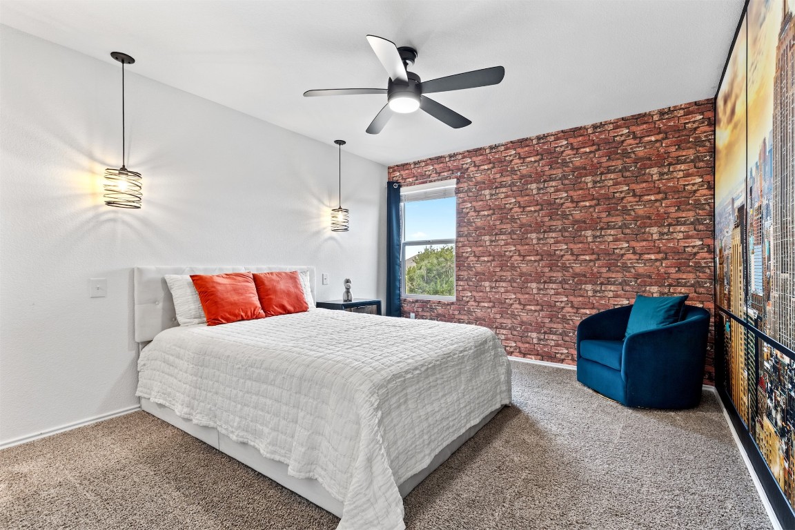 432 Clear Springs Road Georgetown, TX 78628 - Photo 17 of 27 Carpeted bedroom featuring brick wall and a ceiling fan