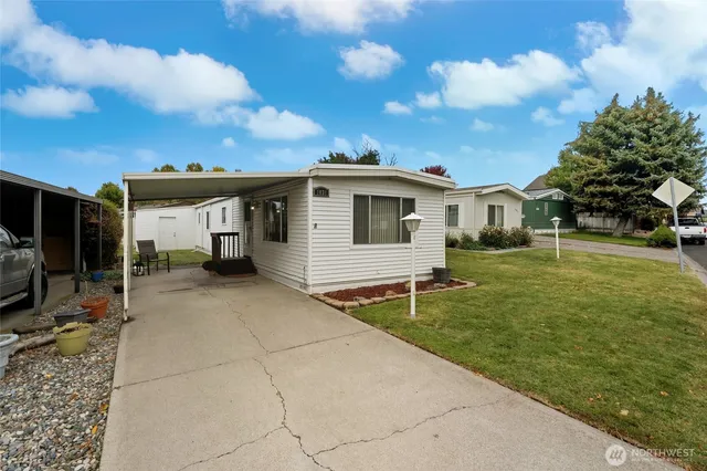 a view of a white house with a big yard and a large tree