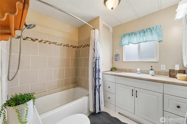 a bathroom with a granite countertop sink a toilet and shower