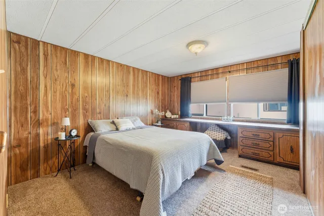 a bedroom with a bed and large window