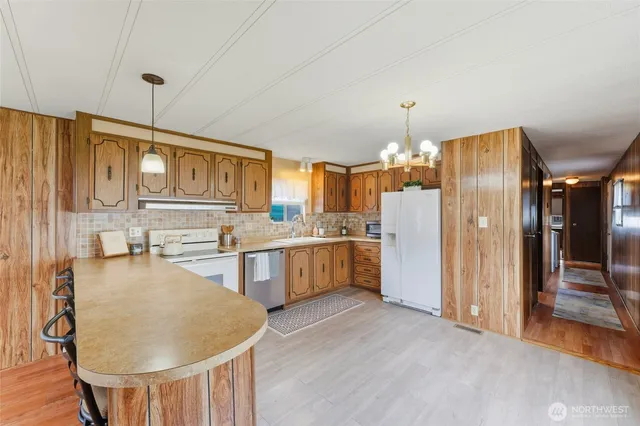 a kitchen with refrigerator a oven and chairs