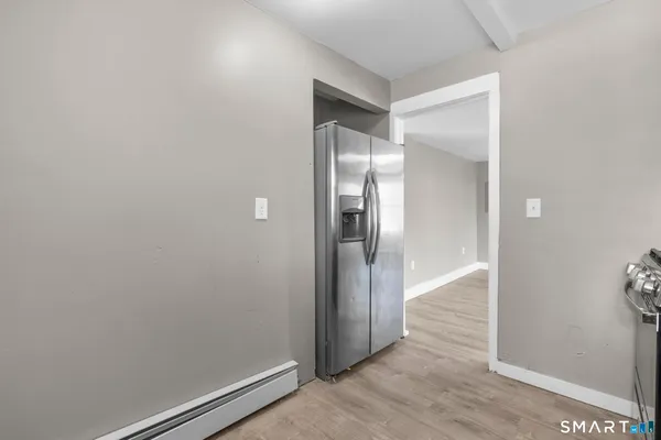an empty room with wooden floor and mirror
