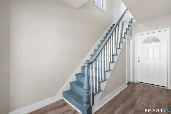 a view of staircase with wooden floor and white walls