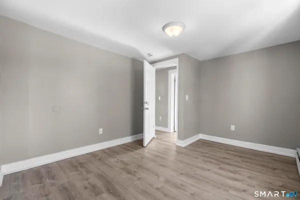 a view of an empty room with wooden floor