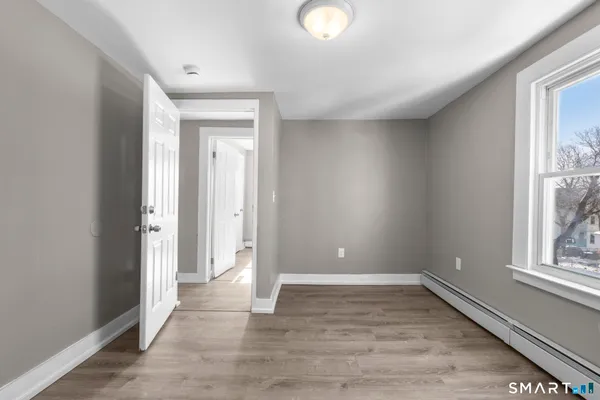 an empty room with wooden floor and windows