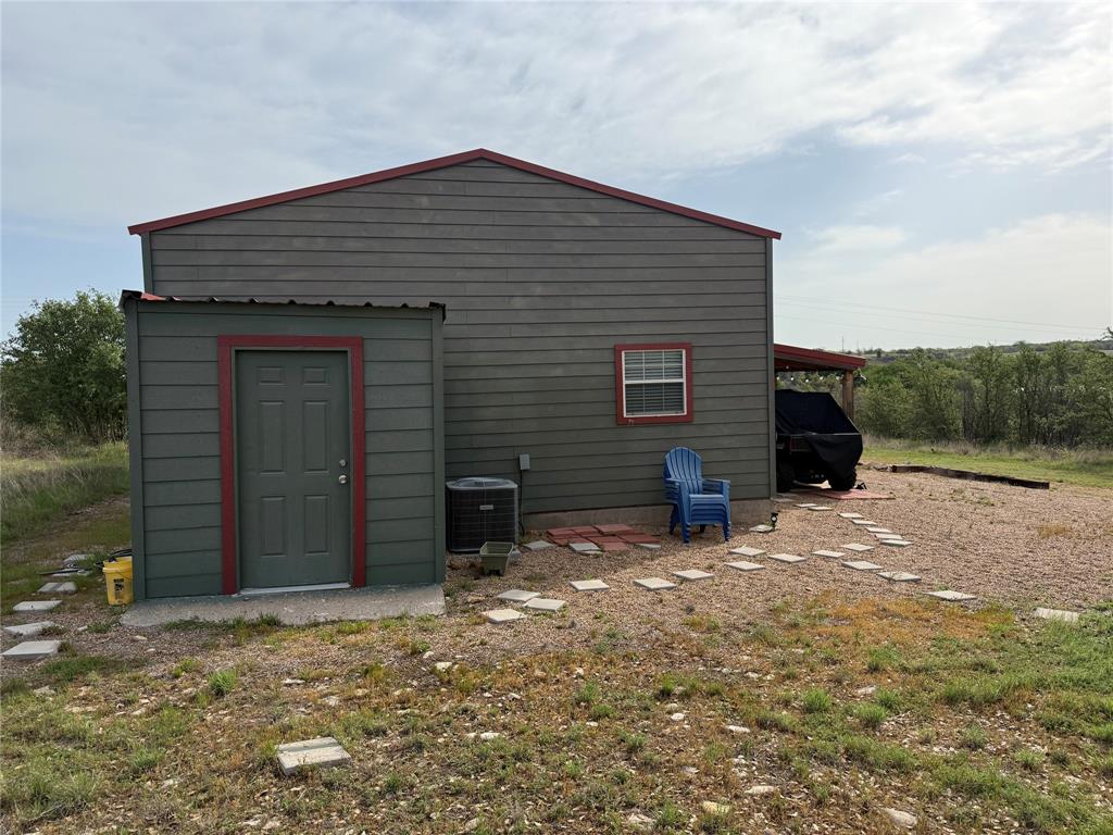 8072 Hells Gate Loop Strawn, TX 76475 - Photo 3 of 16 a view of a wooden house with a yard