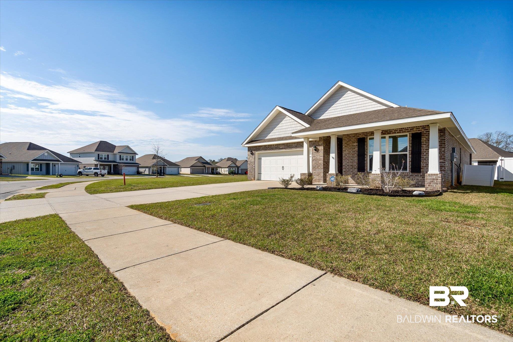 24262 Alydar Loop Daphne, AL 36526 - Photo 18 of 33 View of front of property with an attached garage, brick siding, driveway, a residential view, and a front lawn