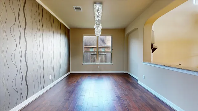 a view of a hallway with wooden floor and stairs