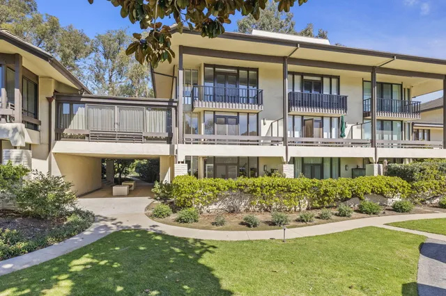 a front view of a residential apartment building with a yard